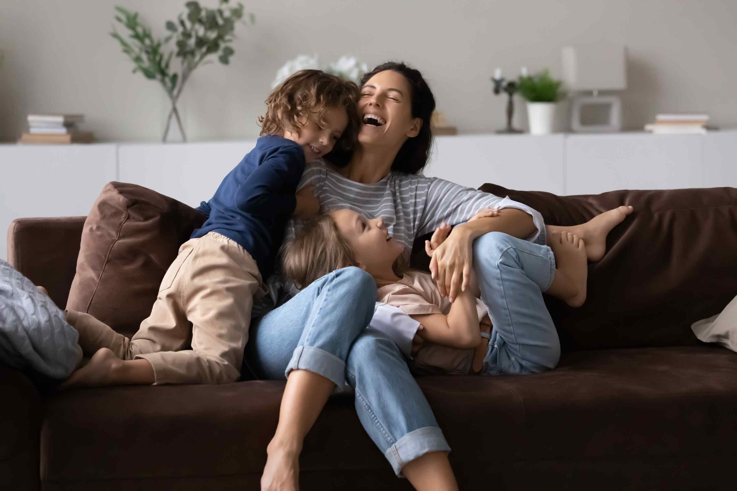 Mother and kids happy sitting on couch
