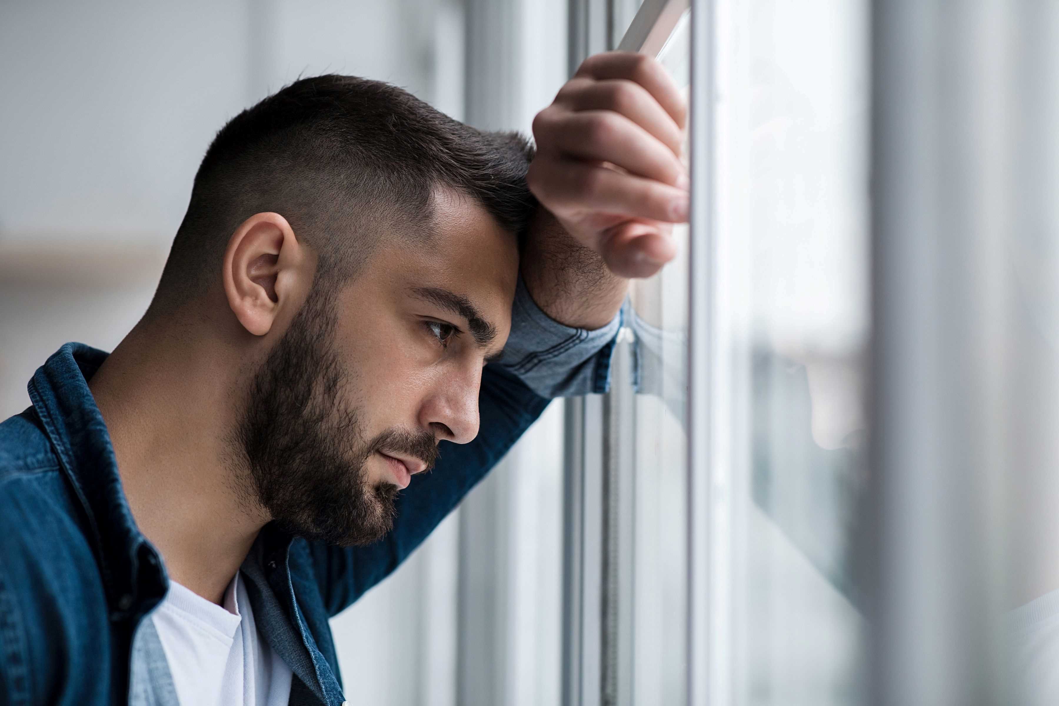 Lonely man staring out a window